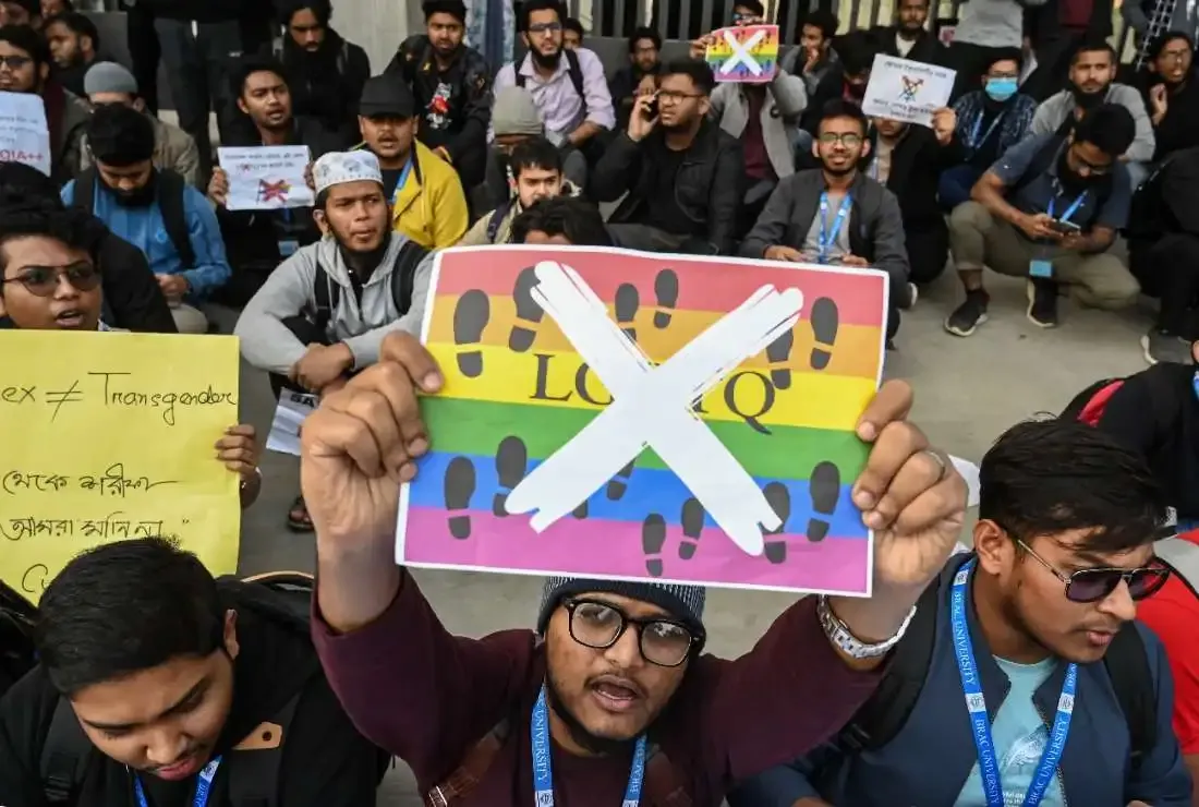 এলজিবিটি পতাকায় ক্রস চিহ্ন দেওয়া প্ল্যাকার্ড হাতে বিক্ষোভরত শিক্ষার্থীরা